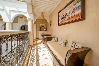 a balcony with a couch and a picture on the wall at RIAD AWINATI Location Privatisée ,piscine chauffée , beau Rooftop in Marrakech