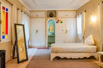 a bedroom with a bed and a mirror at RIAD AWINATI Location Privatisée ,piscine chauffée , beau Rooftop in Marrakech