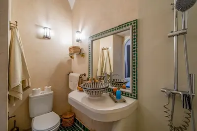 a bathroom with a sink and a toilet and a mirror at RIAD AWINATI Location Privatisée ,piscine chauffée , beau Rooftop in Marrakech