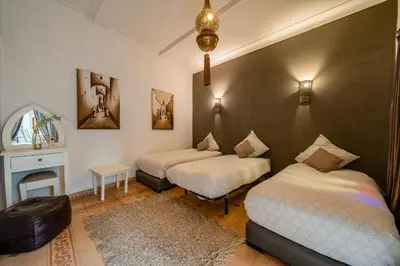 a bedroom with two beds and a fireplace at RIAD AWINATI Location Privatisée ,piscine chauffée , beau Rooftop in Marrakech