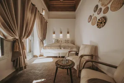 a bedroom with a bed and a couch and a table at Riad Sierra in Marrakech
