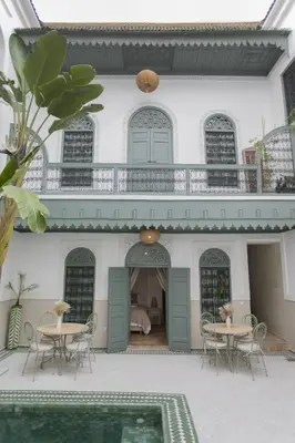 a house with tables and chairs in the courtyard at Riad Sierra in Marrakech