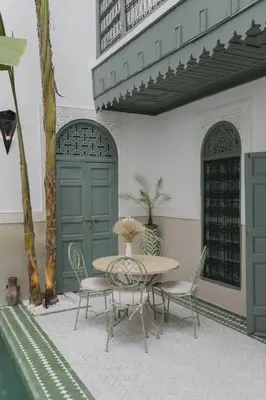 a patio with a table and chairs and a building at Riad Sierra in Marrakech