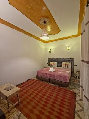 a bedroom with a bed and a table and a ceiling at Riad ViewPoint in Marrakech