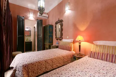 a bedroom with two beds and a mirror at Riad ViewPoint in Marrakech