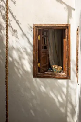 a mirror on the side of a wall with a bowl at Riad Le Coq Berbère in Marrakech