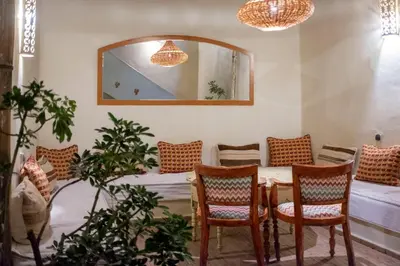 a room with a table and chairs and a mirror at Riad Le Coq Berbère in Marrakech