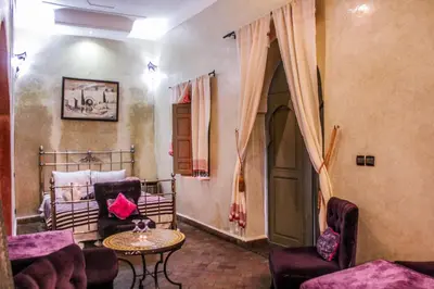 a living room with a bed and a table and chairs at Riad Minorisa in Marrakech