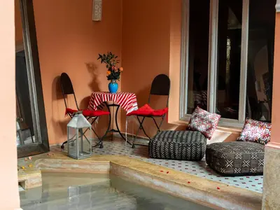 a patio with chairs and a table and a table and chairs at Riad Tahani in Marrakech