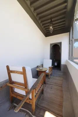 a porch with a rocking chair and a table at Riad Zaouia 44 in Marrakech
