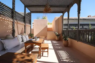 a patio with a table and chairs on a balcony at Riad Zaouia 44 in Marrakech