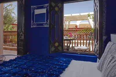 a bedroom with a bed with a mirror and a balcony at Riad 58 Blu in Marrakech