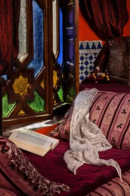 a book sitting on top of a bed next to a window at Riad 58 Blu in Marrakech