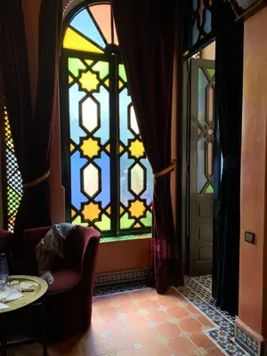 a room with a stained glass window and a table at Riad 58 Blu in Marrakech