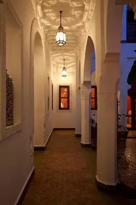 a hallway with white walls and a ceiling with lights at Riad Les Bougainvilliers in Marrakech