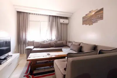 a living room with a couch and a tv at Studio au centre wifi Clim in Marrakech