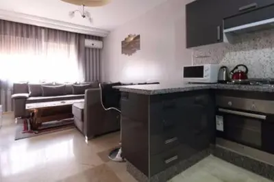 a kitchen and living room with a couch and a microwave at Studio au centre wifi Clim in Marrakech