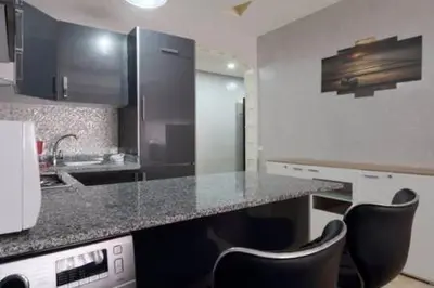 a kitchen with a counter and some chairs in it at Studio au centre wifi Clim in Marrakech