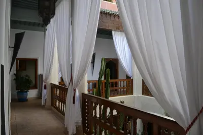 a hallway with white curtains and a cactus at Riad Bayti in Marrakech