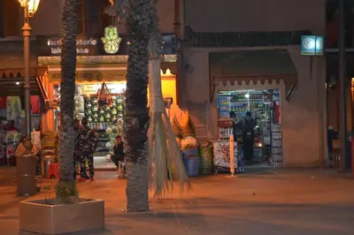 a store with palm trees in a street at night at Riad Bayti in Marrakech