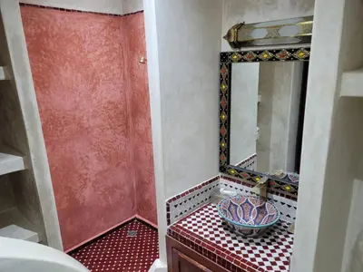 a bathroom with a mirror and a bowl on a counter at Riad Bayti in Marrakech