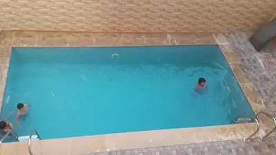 two people swimming in a swimming pool at Appartements Ziad Guéliz in Marrakech