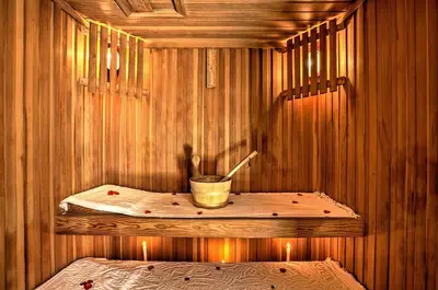 a sauna with a bucket in a wooden room at Riad Kniza in Marrakech