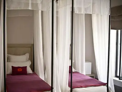 a bedroom with two bunk beds with white curtains at Riad First in Marrakech