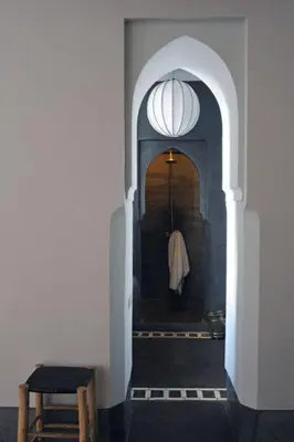 a hallway with an archway with a robe in it at Riad First in Marrakech