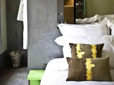 a bedroom with a bed with white sheets and a mirror at Riad First in Marrakech