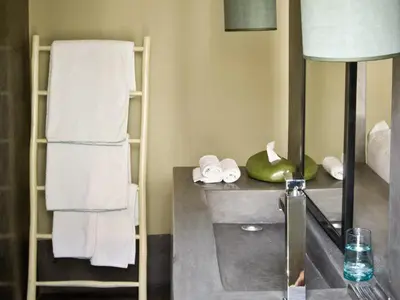 a bathroom with a counter with towels and a mirror at Riad First in Marrakech