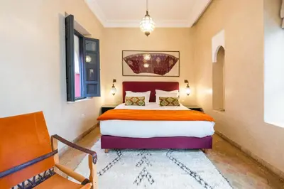 a bedroom with a large bed and a chandelier at Riad D'ari in Marrakech