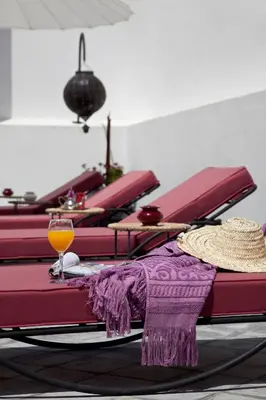 a group of red tables with a glass of orange juice at Riad D'ari in Marrakech