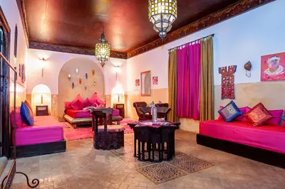 a living room with pink couches and tables at Riad Dar Nadwa in Marrakech