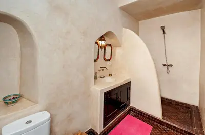 a bathroom with a sink and a toilet and a mirror at Riad Dar Nadwa in Marrakech