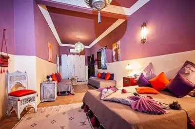 a bedroom with two beds in a room with purple walls at Riad Dar Nadwa in Marrakech