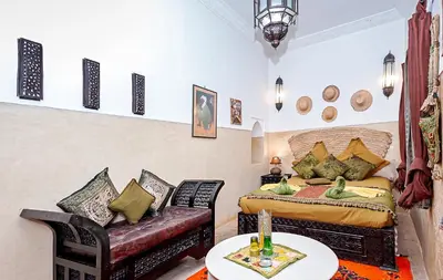 a bedroom with a bed and a couch at Riad Dar Nadwa in Marrakech