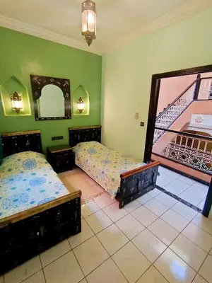 a bedroom with two beds and a mirror at Riad Zahra Marrakech Piscine in Marrakech