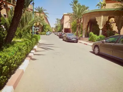 a street with cars parked on the side of the road at Riad Zahra Marrakech Piscine in Marrakech