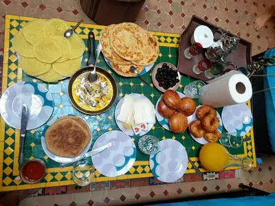 a table topped with plates of food and pancakes at Riad Zahra Marrakech Piscine in Marrakech
