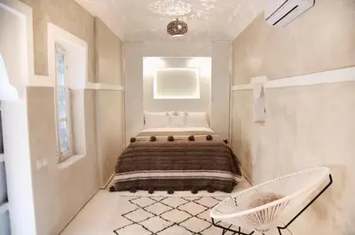 a bedroom with a bed and a chair in it at Riad SHIRAZ in Marrakech