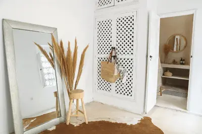 a mirror and a stool in a room with a door at Riad SHIRAZ in Marrakech