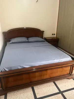a bed with a wooden frame in a bedroom at GoodLife House in Marrakech