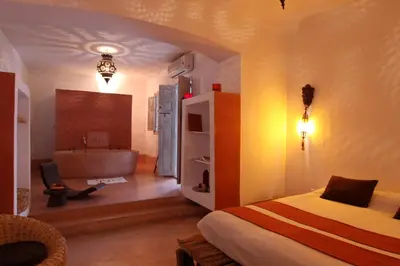 a bedroom with a bed and a tub in a room at Riad O2 in Marrakech