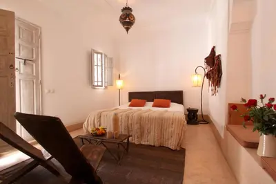 a bedroom with a bed with orange pillows on it at Riad O2 in Marrakech