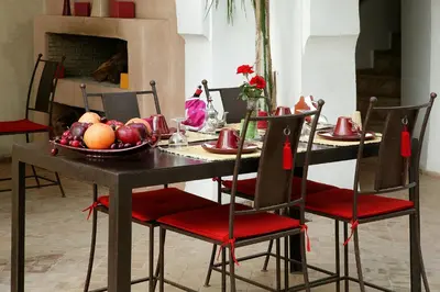 a dining room table with a bowl of fruit on it at Riad O2 in Marrakech