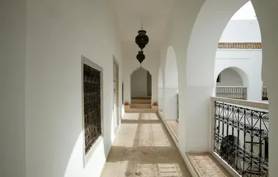a hallway of a building with white walls and a gate at Riad O2 in Marrakech