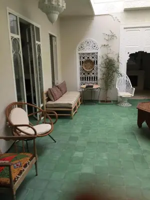 a living room with a green tile floor and chairs at EDEN KAM Riad in Marrakech
