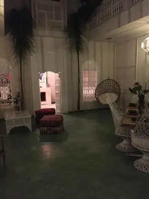 a living room with chairs and a table and a room with at EDEN KAM Riad in Marrakech