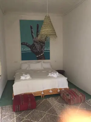 a bedroom with a bed and a painting on the wall at EDEN KAM Riad in Marrakech